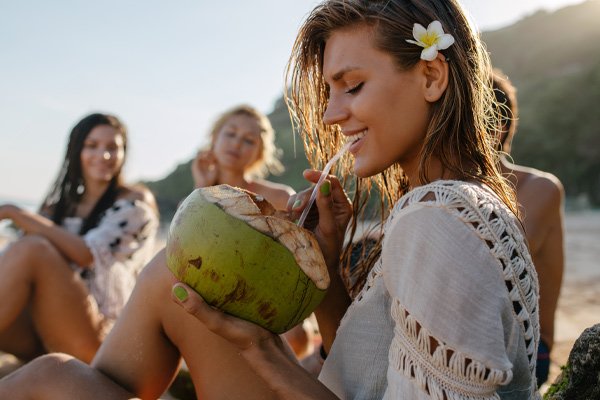 young woman on a beach drinking from a coconut, PRK Brisbane, PRK Fortitude Valley
